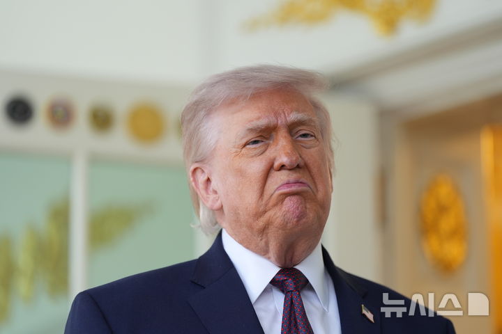 [워싱턴=AP/뉴시스] 도널드 트럼프 미국 대통령이 13일(현지 시간) 백악관에서 배달앱 '도어대시'의 샤론 시먼스로부터 맥도날드를 전달 받은 뒤 기자회견을 하고 있다. 2026.04.14.