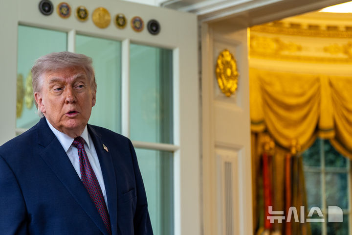 [워싱턴=AP/뉴시스] 도널드 트럼프 미국 대통령이 13일(현지 시간) 백악관에서 배달앱 '도어대시'의 샤론 시먼스로부터 맥도날드를 전달 받은 뒤 기자회견을 하고 있다. 2026.04.14.