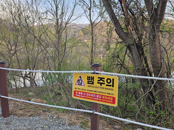[예산=뉴시스] 김덕진 기자=충남 예산군 광시면 산묵지 데크길 곳곳에 '뱀 조심' 문구가 적힌 간판이 설치돼 있다. 2026.04.14. spark@newsis.com *재판매 및 DB 금지