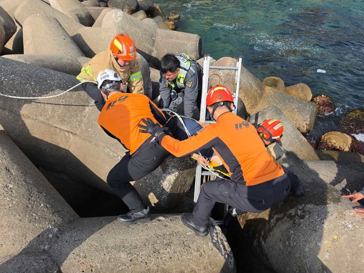 14일 삼척시 원덕읍 월천리 방파제에서 삼척소방서 원덕구급대원들이 테트라포트 사이에 빠진 70대 낚시꾼을 구조하고 있다.(사진=강원소방본부 제공) *재판매 및 DB 금지