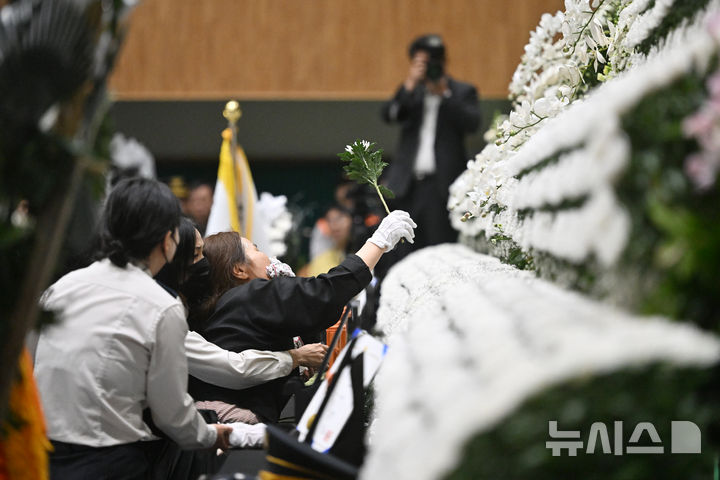[완도=뉴시스] 이영주 기자 = 14일 오전 전남 완도군농어민문화체육센터에서 열린 고(故) 박승원(44) 소방경과 고 노태영(30) 소방교의 영결식에 노 소방교의 유족이 먼저 숨진 고인을 원망하며 영정을 향해 국화를 힘없이 휘두르고 있다. 2026.04.14. leeyj2578@newsis.com
