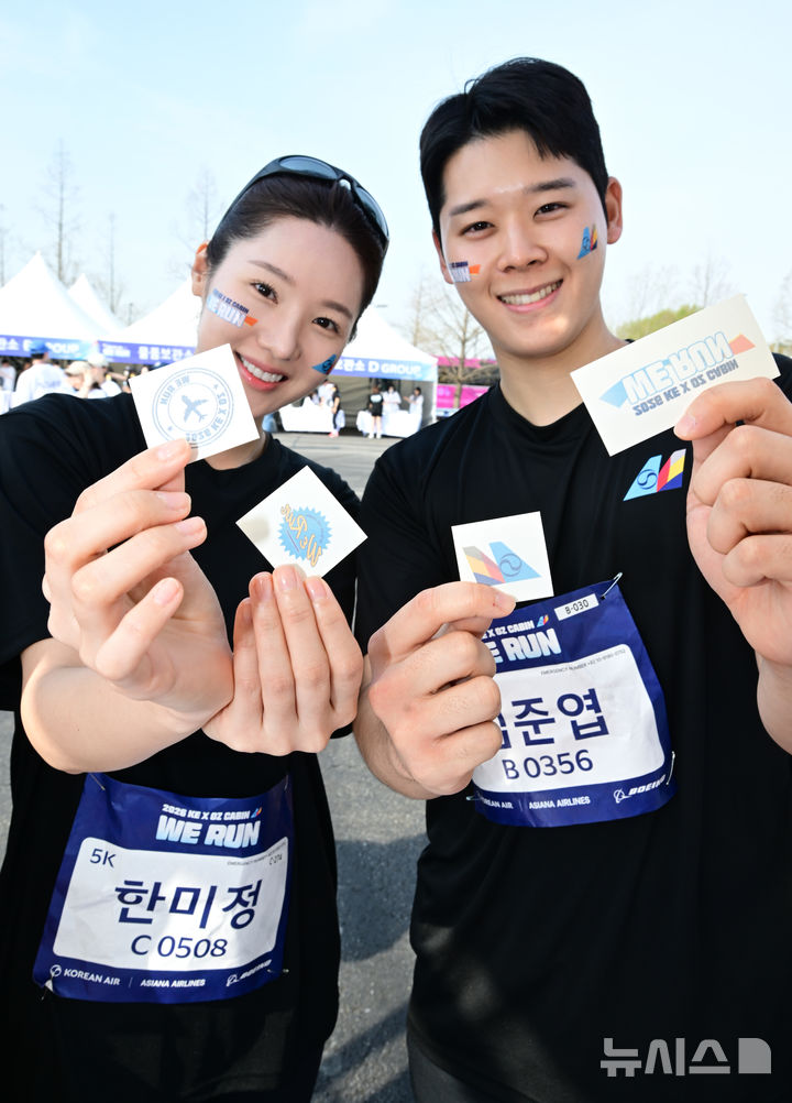 [인천=뉴시스] 박주성 기자 = 통합 항공사 출범을 앞둔 대한항공과 아시아나항공이 14일 인천 중구 BMW드라이빙 센터에서 열린 자선 달리기 행사 '위런'에 참여한 승무원들이 타투 스티커 이벤트를 즐기고 있다. (공동취재). 2026.04.14. photo@newsis.com