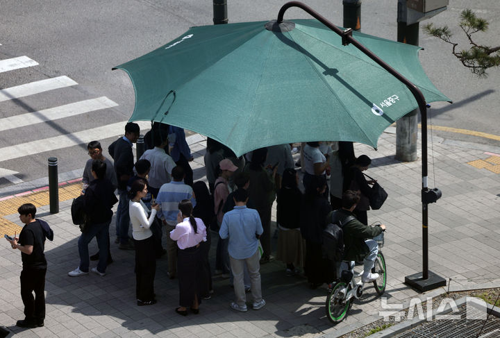 [서울=뉴시스] 홍효식 기자 = 서울 낮 최고기온이 28도까지 오르며 초여름 날씨를 보인 14일 서울 중구 을지로에서 시민들이 햇빛 가림막 아래서 신호를 기다리고 있다. 2026.04.14. yesphoto@newsis.com