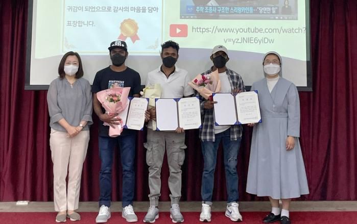 [서울=뉴시스] 2022년 9월 4일 조종사를 구한 공로로 화성시 외국인복지센터장 표창장을 받은 루완씨(가운데)와 동료들이 사진을 찍고 있다. (사진=화성시 외국인복지센터 제공) *재판매 및 DB 금지