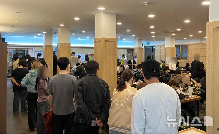 [서울=뉴시스] 백유정 인턴기자= 지난 14일 연화사 공양간에서 학생들이 배식을 위해 줄을 선 모습.2026.04.15.