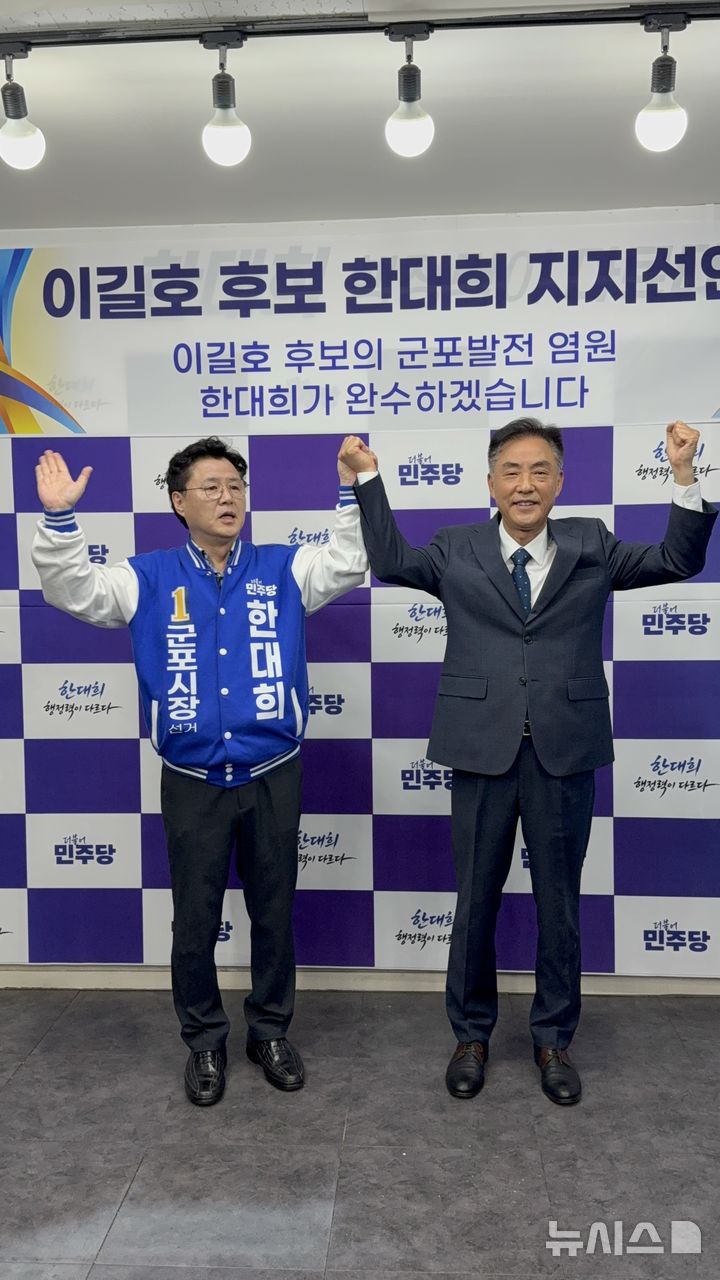 [군포=뉴시스] 이길호(사진 오른쪽) 전 군포시 의회 의장이 한대희 후보 지지를 선언하고 두 팔을 치켜들고 있다. (사진=선거 사무소 제공). 2026.04.15. photo@newsis.com