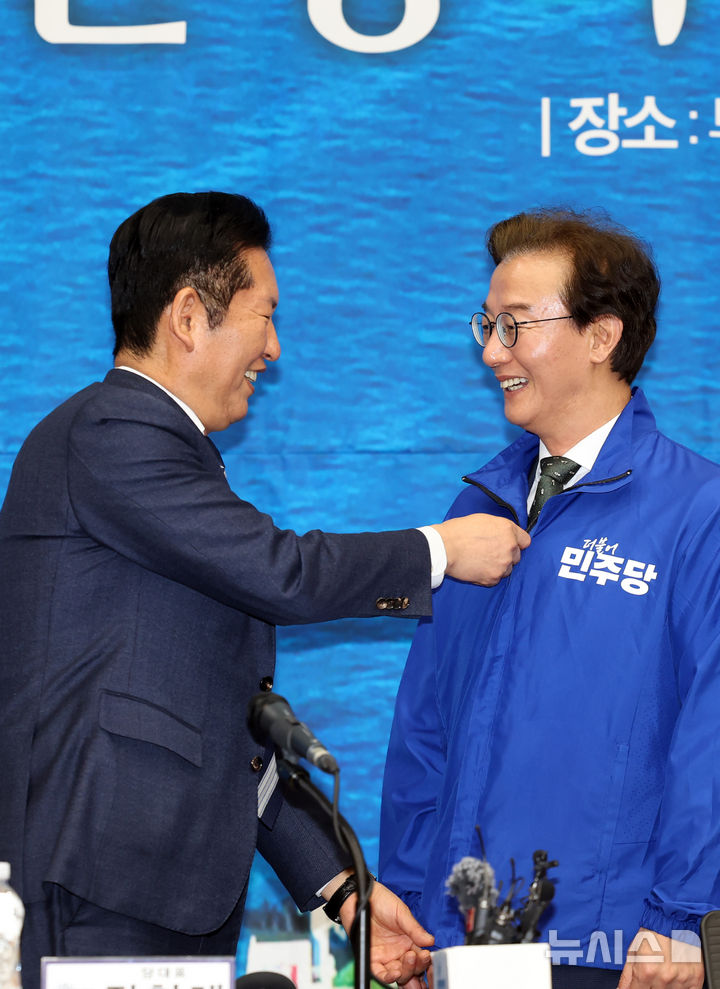  [부산=뉴시스] 하경민 기자 = 정청래 더불어민주당 대표가 15일 부산 동구 부산항 국제전시컨벤션센터에서 열린 부산 현장 최고위원회 회의에 참석, 전재수 부산시장 후보에게 파란 점퍼를 입혀주고 있다. 2026.04.15. yulnetphoto@newsis.com