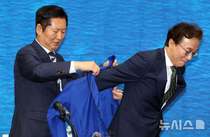  [부산=뉴시스] 하경민 기자 = 정청래 더불어민주당 대표가 15일 부산 동구 부산항 국제전시컨벤션센터에서 열린 부산 현장 최고위원회 회의에 참석, 전재수 부산시장 후보에게 파란 점퍼를 입혀주고 있다. 2026.04.15. yulnetphoto@newsis.com