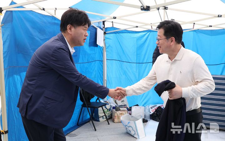 [서울=뉴시스] 조성봉 기자 = 김용 전 민주연구원 부원장이 15일 오전 서울 여의도 국회 본청 앞에서 이원택 전북도지사 후보의 '식사비 대납' 의혹에 대한 재감찰을 요구하며 5일째 단식 농성중인 안호영 더불어민주당 의원과 악수를 하고 있다. 2026.04.15. suncho21@newsis.com