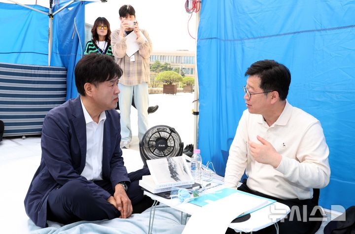 [서울=뉴시스] 조성봉 기자 = 김용 전 민주연구원 부원장이 15일 오전 서울 여의도 국회 본청 앞에서 이원택 전북도지사 후보의 '식사비 대납' 의혹에 대한 재감찰을 요구하며 5일째 단식 농성중인 안호영 더불어민주당 의원과 대화를 하고 있다. 2026.04.15. suncho21@newsis.com