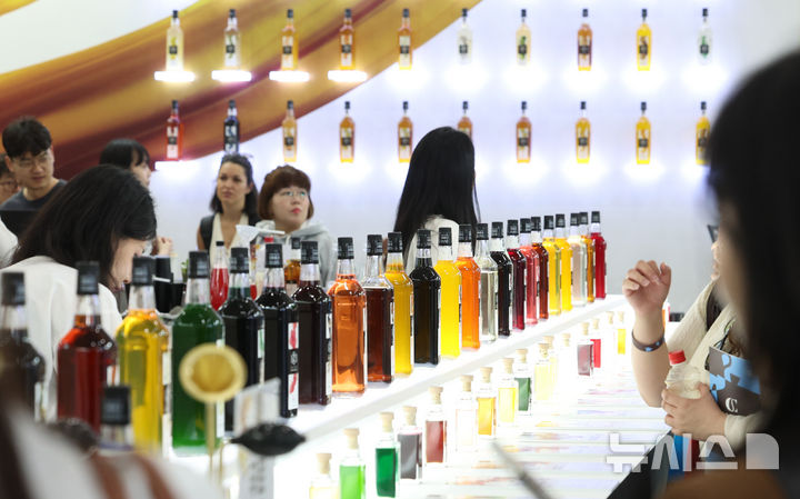 [서울=뉴시스] 이영환 기자 = 15일 서울 강남구 코엑스에서 열린 2026 서울커피엑스포를 찾은 관람객들이 시럽을 살펴보고 있다. 2026.04.15. 20hwan@newsis.com