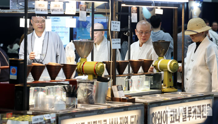 [서울=뉴시스] 이영환 기자 = 15일 서울 강남구 코엑스에서 열린 2026 서울커피엑스포를 찾은 스님들이 커피 원두를 살펴보고 있다. 2026.04.15. 20hwan@newsis.com
