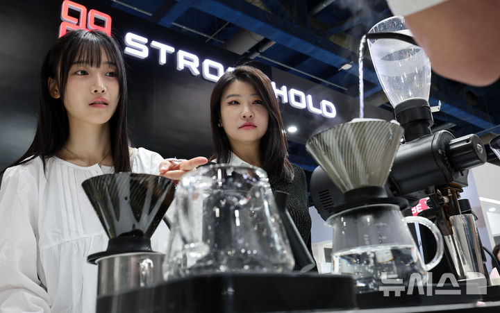 [서울=뉴시스] 이영환 기자 = 15일 서울 강남구 코엑스에서 열린 2026 서울커피엑스포를 찾은 관람객들이 커피 내리는 과정에 대해 설명을 듣고 있다. 2026.04.15. 20hwan@newsis.com