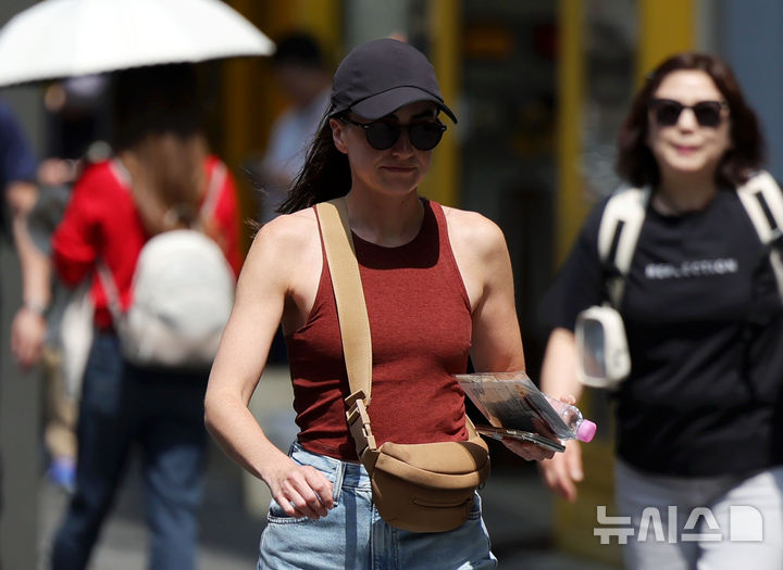 [서울=뉴시스] 홍효식 기자 = 서울 낮 최고기온이 26도까지 오르며 초여름 날씨를 보인 15일 서울 중구 명동에서 한 관광객이 민소매 차림으로 이동하고 있다. 2026.04.15. yesphoto@newsis.com