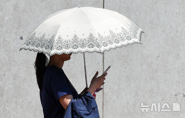 [대구=뉴시스] 이무열 기자 = 대구 낮 최고기온이 25도까지 오르며 초여름 날씨를 보인 15일 대구 중구 동성로에서 반팔 차림을 한 시민이 양산을 들고 이동하고 있다. 2026.04.15. lmy@newsis.com