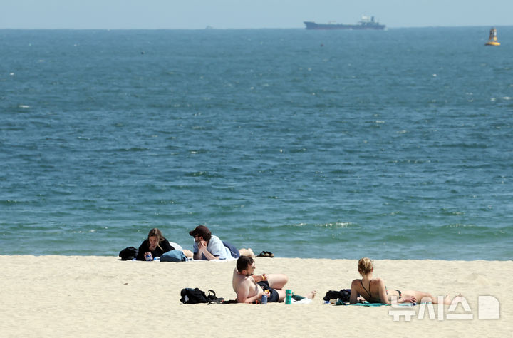  [부산=뉴시스] 하경민 기자 = 전국적으로 초여름 날씨를 보인 15일 부산 해운대구 해운대해수욕장을 찾은 외국인들이 일광욕을 즐기고 있다. 2026.04.15. yulnetphoto@newsis.com