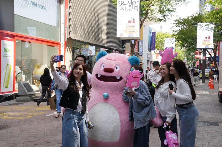[서울=뉴시스] 외국인 관광객들이 명동 거리 일대에서 해치와 사진촬영을 하고 있는 모습. (사진=롯데면세점 제공) *재판매 및 DB 금지