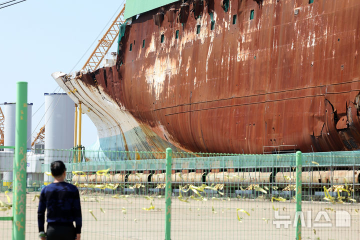 [목포=뉴시스] 이영주 기자 = 세월호 참사 12주기를 맞은 16일 오전 세월호 선체가 거치된 전남 목포신항에서 한 추모객이 파손된 선체를 바라보고 있다. 2026.04.16. photo@newsis.com