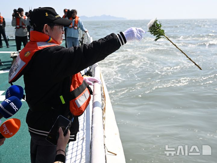 [진도=뉴시스] 이현행 기자 = 세월호 참사 12주기인 16일 오전 전남 진도군 맹골수도에서 열린 선상추모식 중 세월호 참사 유족이 참사 해역으로 국화를 던지고 있다. 2026.04.16. lhh@newsis.com