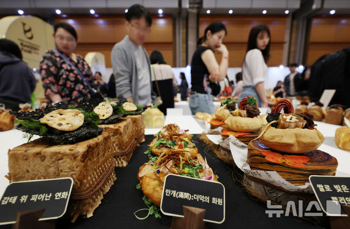 [서울=뉴시스] 조성우 기자 = 16일 서울 강남구 코엑스에서 열린 2026 한국국제베이커리페어를 찾은 관람객이 베이커리 작품을 살펴보고 있다. 2026.04.16. xconfind@newsis.com