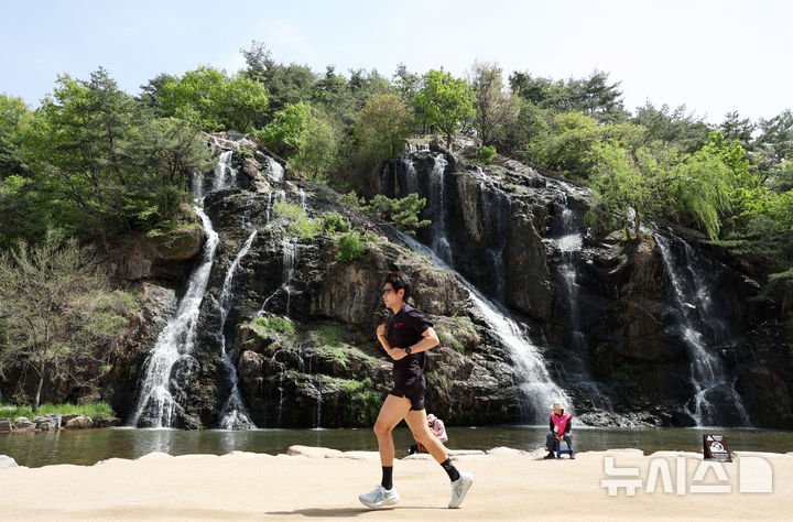 [서울=뉴시스] 김진아 기자 = 낮 최고기온이 28까지 오르는 등 초여름 날씨를 보인 16일 서울 서대문구 홍제천 인공폭포를 찾은 시민이 가벼운 옷차림으로 달리기를 하고 있다. 2026.04.16. bluesoda@newsis.com