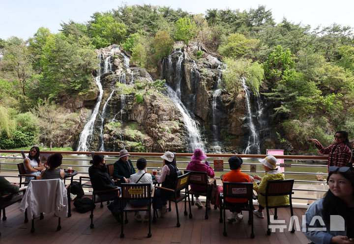 [서울=뉴시스] 김진아 기자 = 낮 최고기온이 28까지 오르는 등 초여름 날씨를 보인 16일 서울 서대문구 홍제천 인공폭포를 찾은 시민들이 폭포를 바라보며 더위를 식히고 있다. 2026.04.16. bluesoda@newsis.com