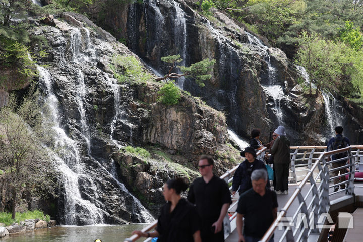 [서울=뉴시스] 김진아 기자 = 낮 최고기온이 28까지 오르는 등 초여름 날씨를 보인 지난 16일 서울 서대문구 홍제천 인공폭포를 찾은 시민들이 폭포를 바라보며 더위를 식히고 있다. 2026.04.18. bluesoda@newsis.com