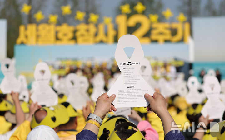 [안산=뉴시스] 최동준 기자 = 16일 경기 안산 화랑유원지에서 열린 세월호 참사 12주기 기억식에서 참석자들이 노란 리본을 들며 '약속의 퍼포먼스'를 하고 있다. 2026.04.16. photocdj@newsis.com