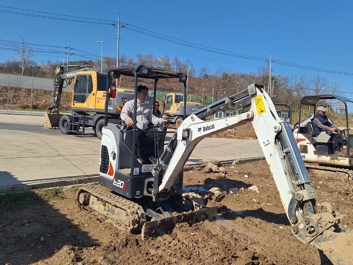 [고창=뉴시스] 고창군의 '소형특수농기계 면허취득 지원 교육'에 참여한 한 농업인이 소형 굴착기 운전 실습을 하고 있다. *재판매 및 DB 금지