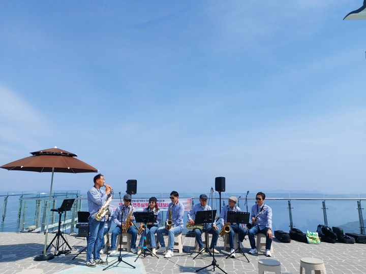 [통영=뉴시스] 신정철 기자= 통영관광개발공사는 경남 통영시 미륵산에 소재한 통영케이블카 상부역사 스카이워크 전망대에서 진행한 18개 팀의 버스킹 공연이 마무리됐다고 17일 밝혔다. 사진은 서재수 색스폰연주 공연 모습.(사진=통영관광개발공사 제공),2026.04.17. photo@newsis.com *재판매 및 DB 금지