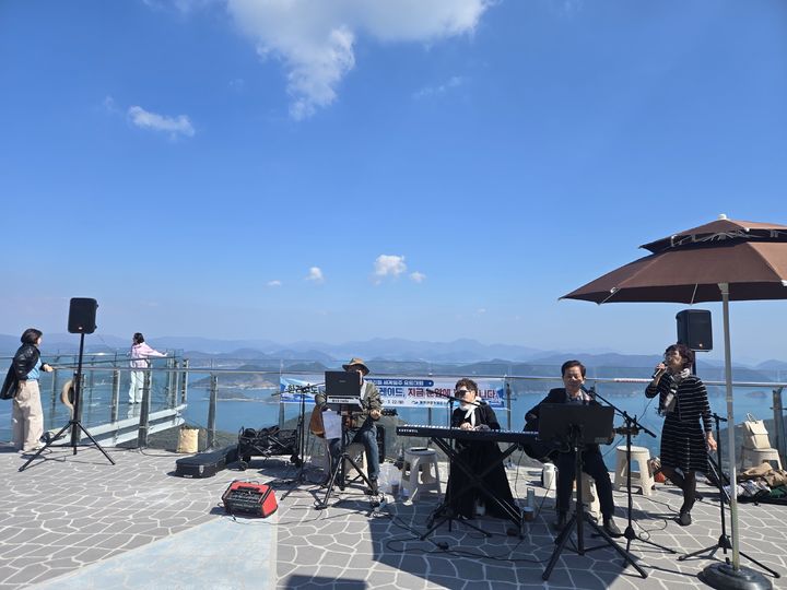 [통영=뉴시스] 신정철 기자= 통영관광개발공사는 경남 통영시 미륵산에 소재한 통영케이블카 상부역사 스카이워크 전망대에서 진행한 18개 팀의 버스킹 공연이 마무리됐다고 17일 밝혔다. 사진은 통영하모니 공연 모습.(사진=통영관광개발공사 제공),2026.04.17. photo@newsis.com *재판매 및 DB 금지
