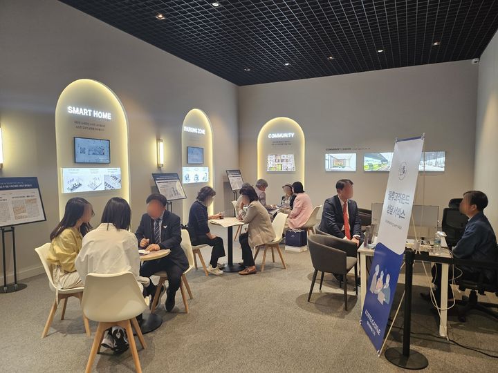 [서울=뉴시스] 김여림 인턴기자=분양 희망자들이 입주 관련 설명을 듣고 있는 모습이다. *재판매 및 DB 금지