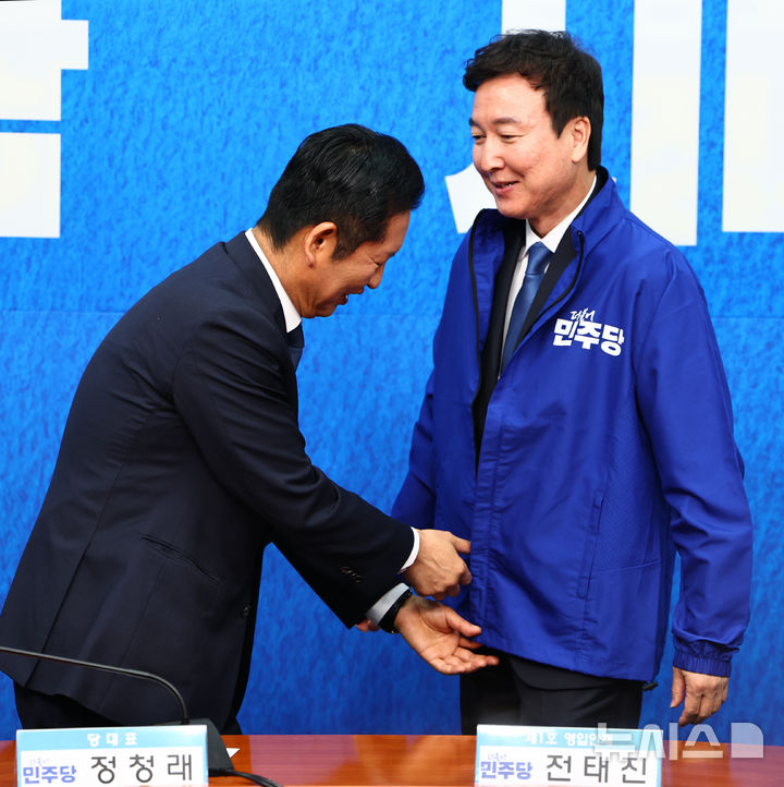 [서울=뉴시스] 김명년 기자 = 정청래 더불어민주당 대표가 17일 서울 여의도 국회에서 열린 더불어민주당 인재영입식에서 1호 인재인 전태진 변호사에게 당 점퍼를 입혀주고 있다. 전 변호사는 당 울산시장 예비후보로 출마하는 김상욱 의원의 지역구인 울산 남갑에 전략 공천될 전망이다. 2025.04.17. kmn@newsis.com