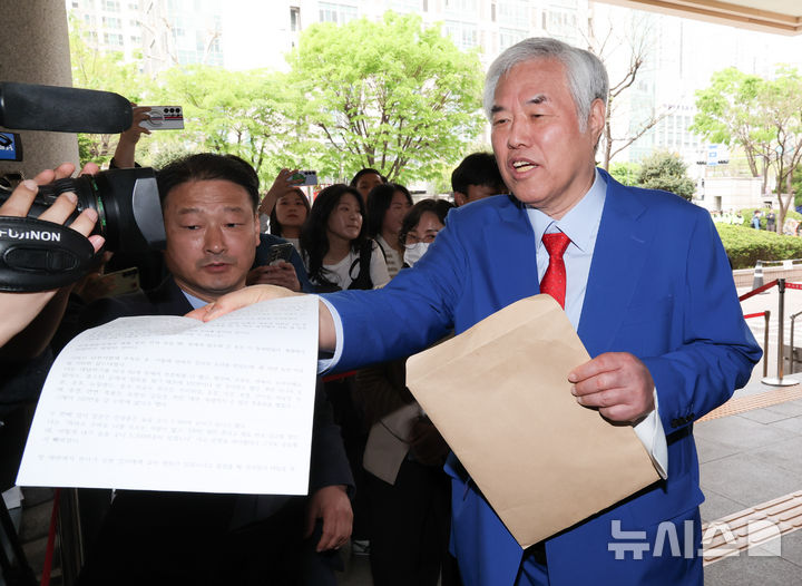 [서울=뉴시스] 황준선 기자 = 서울서부지방법원 난동 사건의 배후 의혹을 받아 재판에 넘겨진 전광훈 사랑제일교회 목사가 17일 서울 마포구 서울서부지방법원에서 열린 2차 공판을 마친 뒤 법원을 나서며 취재진에게 소명 자료를 건네고 있다. 2026.04.17. hwang@newsis.com