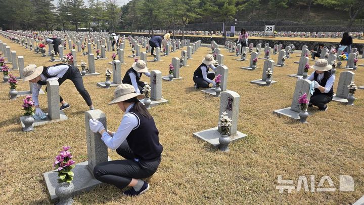 [안양=뉴시스] 안양 정심 여자 중고등학교 학생들이 현충원을 방문해 묘역 정화 봉사활동을 벌이고 있다. (사진=정심 여자 중고등학교 제공).2026.04.18.photo@newsis.com