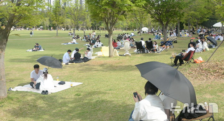 [전주=뉴시스] 김얼 기자 = 무더운 봄 날씨가 찾아온 18일 전북 전주시 세병공원을 찾은 시민들이 그늘 아래에서 피크닉을 즐기고 있다. 2026.04.18. pmkeul@newsis.com