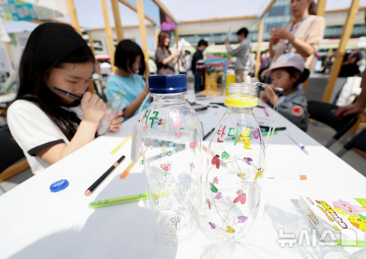 [서울=뉴시스] 김진아 기자 = 지구의 날(매년 4월 22일)을 맞아 18일 서울 종로구 광화문광장에서 폐기물 감량을 주제로 열린 '2026 지구의 날 기념행사'에서 어린이들이 페트병을 활용한 조명 만들기를 하고 있다. 2026.04.18. bluesoda@newsis.com