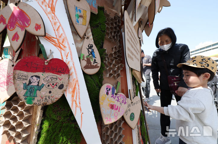 [서울=뉴시스] 김진아 기자 = 지구의 날(매년 4월 22일)을 맞아 18일 서울 종로구 광화문광장에서 폐기물 감량을 주제로 열린 '2026 지구의 날 기념행사'에서 한 어린이가 지구를 아끼기 위한 실천메시지를 보고 있다. 2026.04.18. bluesoda@newsis.com