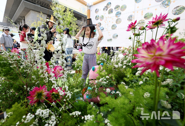 [서울=뉴시스] 김진아 기자 = 지구의 날(매년 4월 22일)을 맞아 18일 서울 종로구 광화문광장에서 폐기물 감량을 주제로 열린 '2026 지구의 날 기념행사'에서 한 어린이가 부스에 마련된 정원에서 사진을 찍고 있다. 2026.04.18. bluesoda@newsis.com