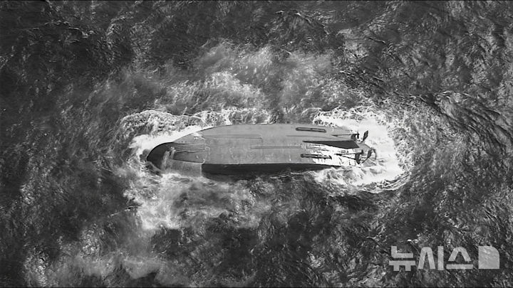 [AP/뉴시스] 미 해안경비대 제공 사진으로 18일 경비대의 HC-130 허큘리스 항공기가 사이판 근해서 전복되어 있는 마리아나호 위를 지나고 있다 