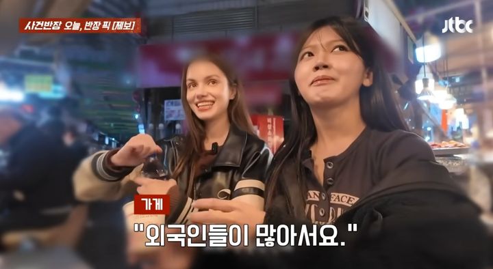 [서울=뉴시스] 서울 광장시장의 한 노점에서 상인이 관광객에게 2000원짜리 생수를 건네고 있다. (사진=JTBC '사건반장' 캡처) 2026.04.19. 