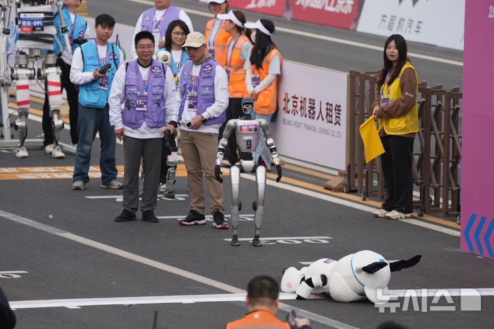 [베이징=AP/뉴시스]19일(현지시간) 베이징 이좡(E-Town)에서 열린 '제2회 휴머노이드 로봇 하프마라톤 대회'에서 한 참가 로봇이 출발선에서 쓰러져 있다. 2026.04.19.