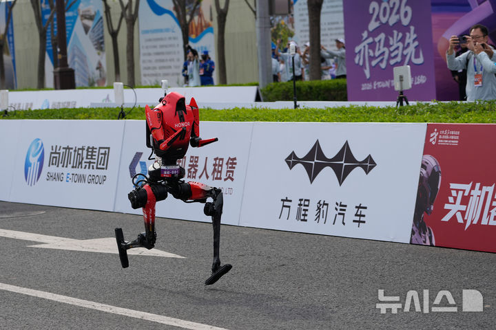 [베이징=AP/뉴시스] 19일(현지시간) 베이징 이좡(E-Town)에서 열린 '제2회 휴머노이드 로봇 하프마라톤 대회'에서 아너(Honor)사의 휴머노이드 로봇 '샨뎬'이 출발선을 지나 달려가고 있다. 2026.04.19.