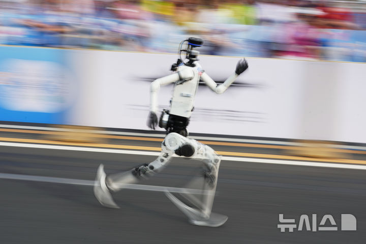 [베이징=AP/뉴시스] 19일(현지시간) 베이징 이좡(E-Town)에서 열린 '제2회 휴머노이드 로봇 하프마라톤 대회'에서 한 참가 로봇이 출발선을 지나 달려가고 있다. 2026.04.19.
