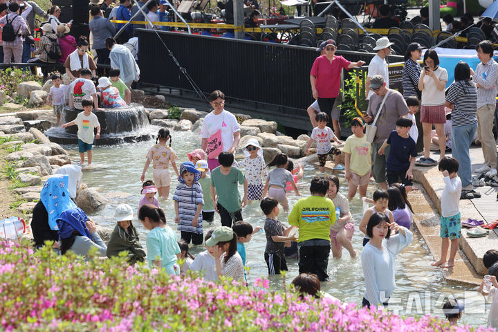 [서울=뉴시스] 권창회 기자 = 서울 낮기온이 29도까지 오르는 등 초여름 더위가 이어지는 19일 서울 노원구 불암산 나비정원에서 열린 2026 불암산 철쭉제를 찾은 아이들이 물놀이를 하고 있다. 2026.04.19. kch0523@newsis.com