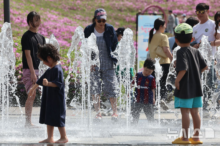 [서울=뉴시스] 권창회 기자 = 서울 낮기온이 29도까지 오르는 등 초여름 더위가 이어지는 19일 서울 노원구 불암산 나비정원에서 열린 2026 불암산 철쭉제를 찾은 아이들이 물놀이를 하고 있다. 2026.04.19. kch0523@newsis.com