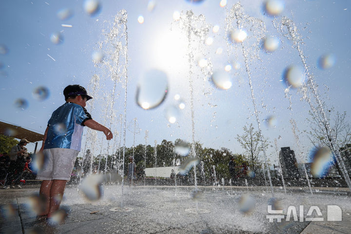 [서울=뉴시스] 권창회 기자 = 서울 낮기온이 29도까지 오르는 등 초여름 더위가 이어지는 19일 서울 노원구 불암산 나비정원에서 열린 2026 불암산 철쭉제를 찾은 아이들이 물놀이를 하고 있다. 2026.04.19. kch0523@newsis.com