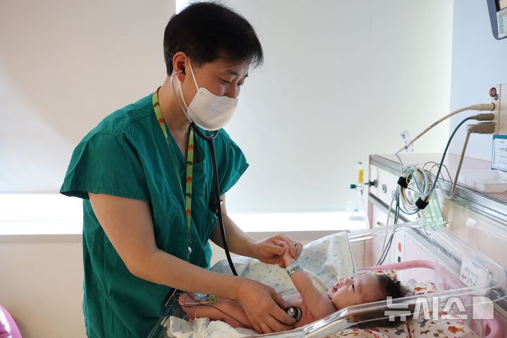 [서울=뉴시스] 서울아산병원은 선천성 폐기형으로 폐가 2배 부푼 신생아 한결이(남)를 에크모 보조 하에 수술하는 데 성공했다. 사진은 지난 3월 이병섭 서울아산병원 신생아과 교수가 퇴원을 앞둔 한결이를 진료하는 모습. (사진= 서울아산병원 제공)
