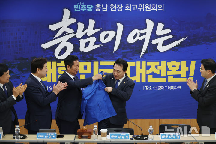[보령=뉴시스] 고승민 기자 = 정청래 더불어민주당 대표가 20일 충남 보령머드테마파크 컨벤션관에서 열린 현장 최고위원회의에서 박수현 충남도지사 후보에게 선거 점퍼를 입혀주고 있다. 2026.04.20. kkssmm99@newsis.com