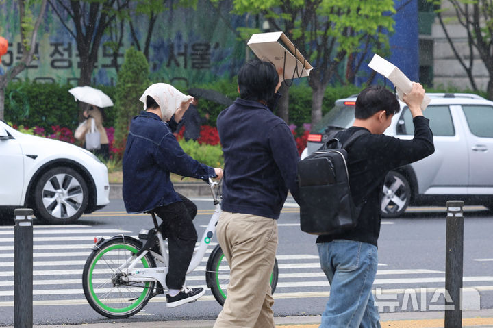 [서울=뉴시스] 권창회 기자 = 백곡을 기름지게 하는 봄비가 내린다는 절기상 '곡우(穀雨)'인 지난 20일 서울 중구 서울시의회 인근에서 우산을 챙기지 못한 시민들이 손수건으로 비를 피하고 있다. 2026.04.23. kch0523@newsis.com